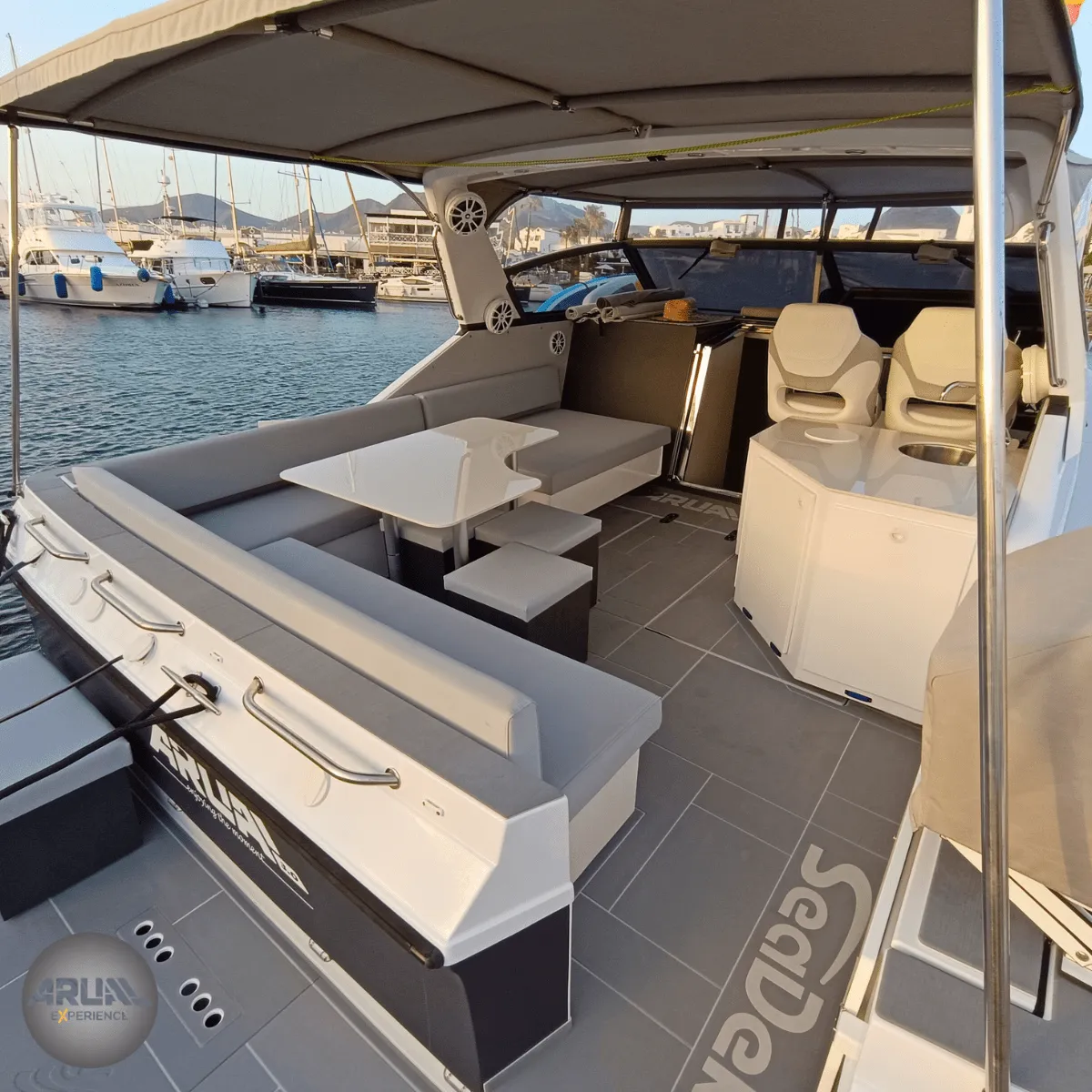Zona de descanso con sillones de diseño en el yate ARUAL, reflejo del lujo y confort de nuestras excursiones privadas en barco en Lanzarote.