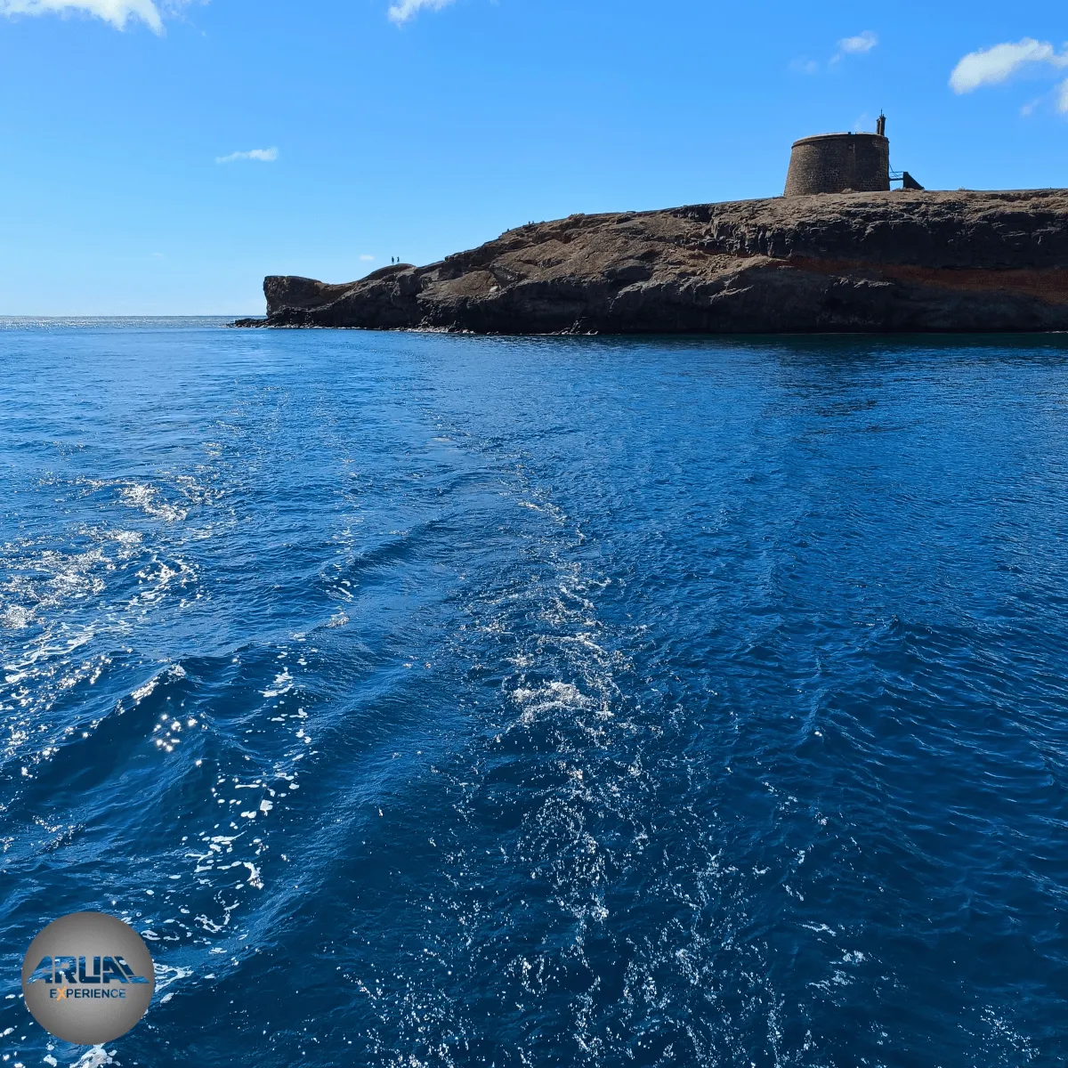 La Cala del Castillo de San Marcial de Rubicón, uno de los paisajes volcánicos que podrás contemplar durante tu tour náutico por Playa Blanca con ARUAL Experience.
