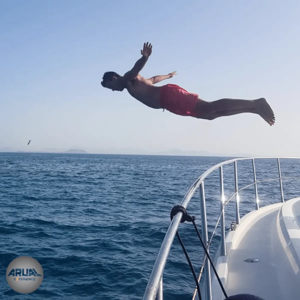 Cliente saltando al agua desde la cubierta de nuestro barco ARUAL, en Lanzarote.
