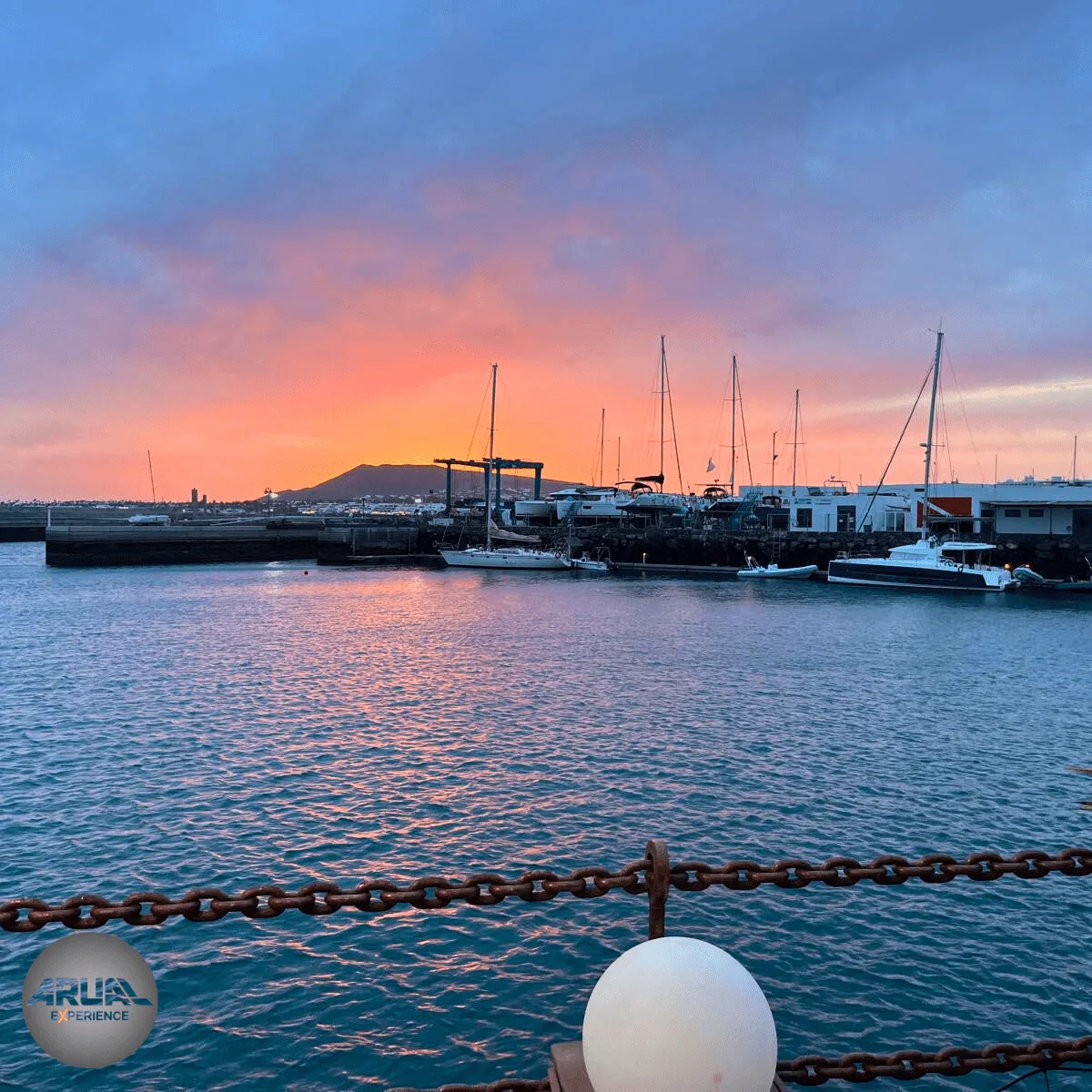Puesta de sol en Lanzarote reflejada sobre el mar en un ambiente de calma y luz dorada.