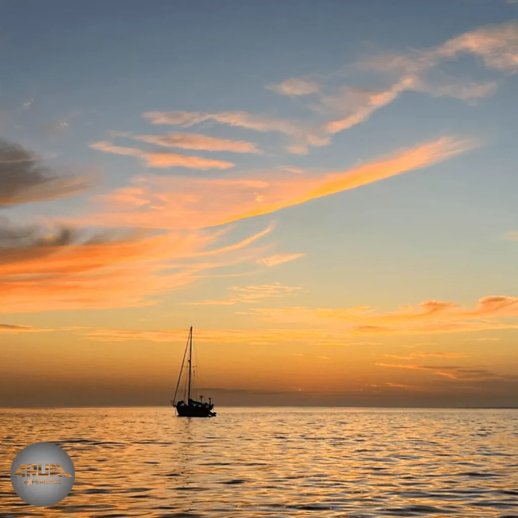 Puesta de sol en Lanzarote con nubes en forma de penachos reflejando tonos dorados y rosados, creando un paisaje espectacular sobre el mar.