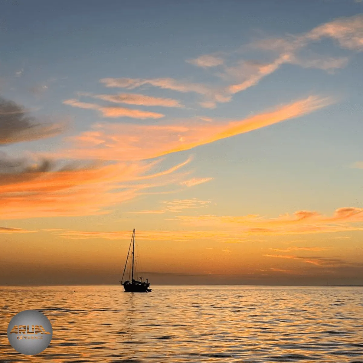 Puesta de sol en Lanzarote con nubes doradas y rosadas sobre el mar al atardecer.