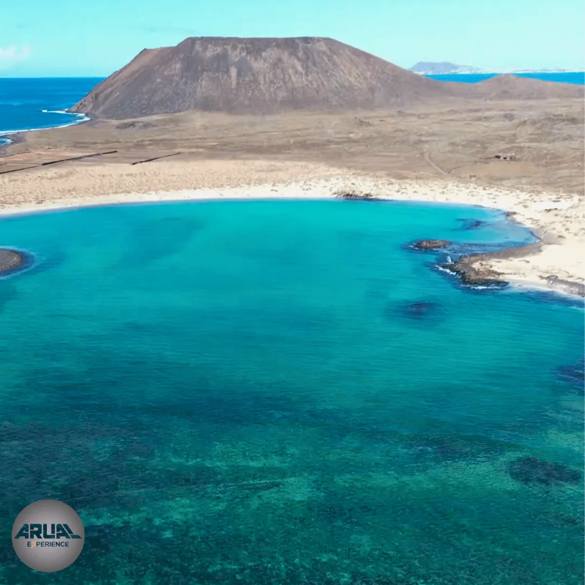 Vista aérea de la Playa de la Concha, reserva natural al norte de Fuerteventura, punto final de una ruta privilegiada en barco desde Lanzarote hacia la Isla de Lobos.