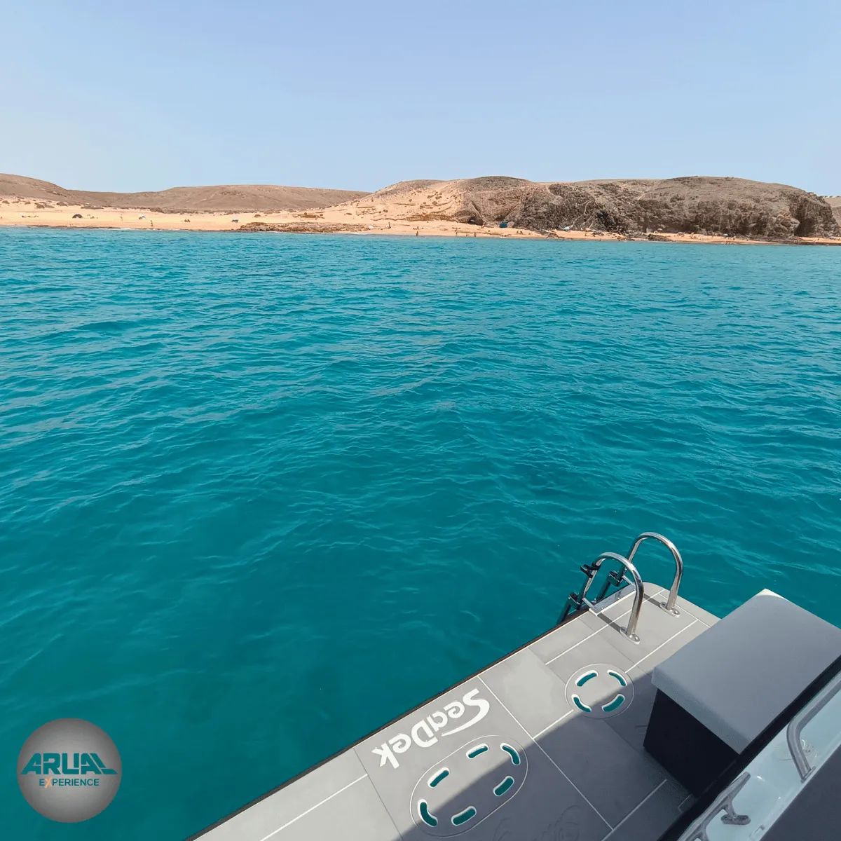 Vista desde la cubierta del ARUAL durante la navegación hacia las calas vírgenes de Papagayo, con fondo volcánico y aguas cristalinas.